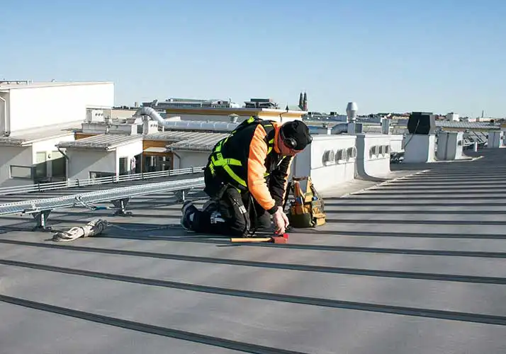 Plåtslagare utför arbete på tak